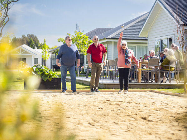 Two men and a woman enjoying a game of Petanque
