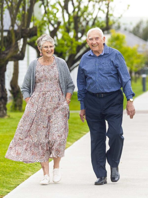 Older couple walking on the footpath