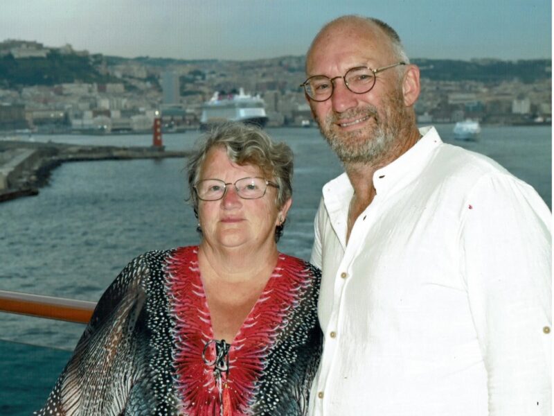 Man and woman standing with sea behind them